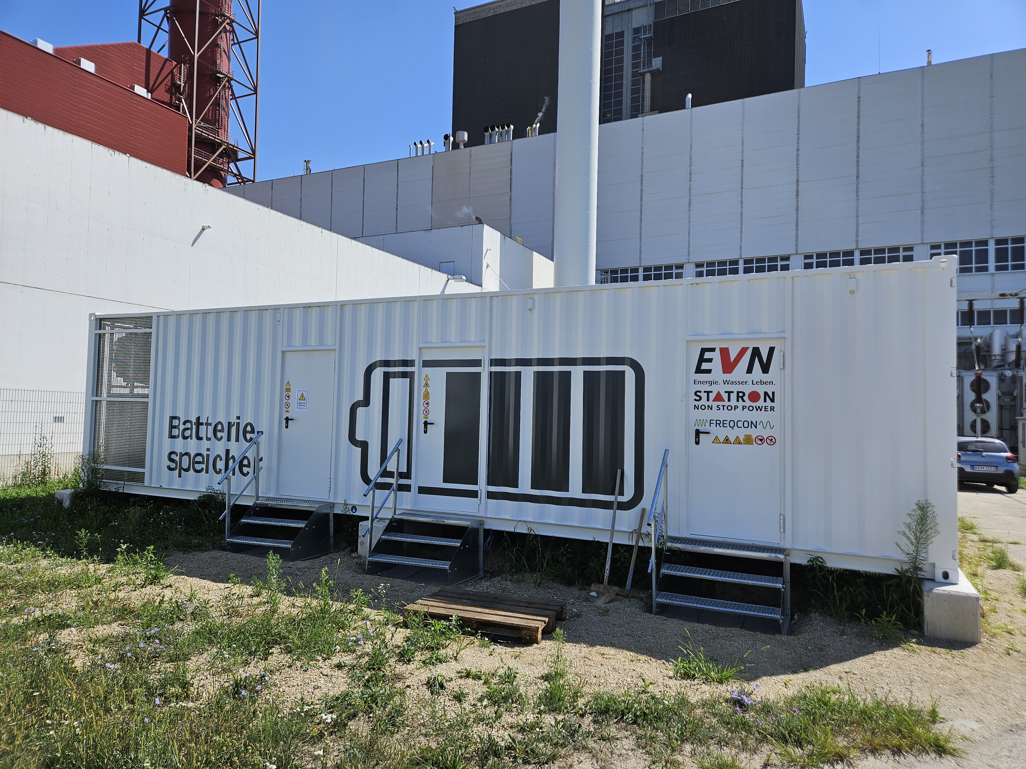 Filas de contenedores blancos de almacenamiento de baterías en la instalación BESS a escala de red de Theiss, Austria