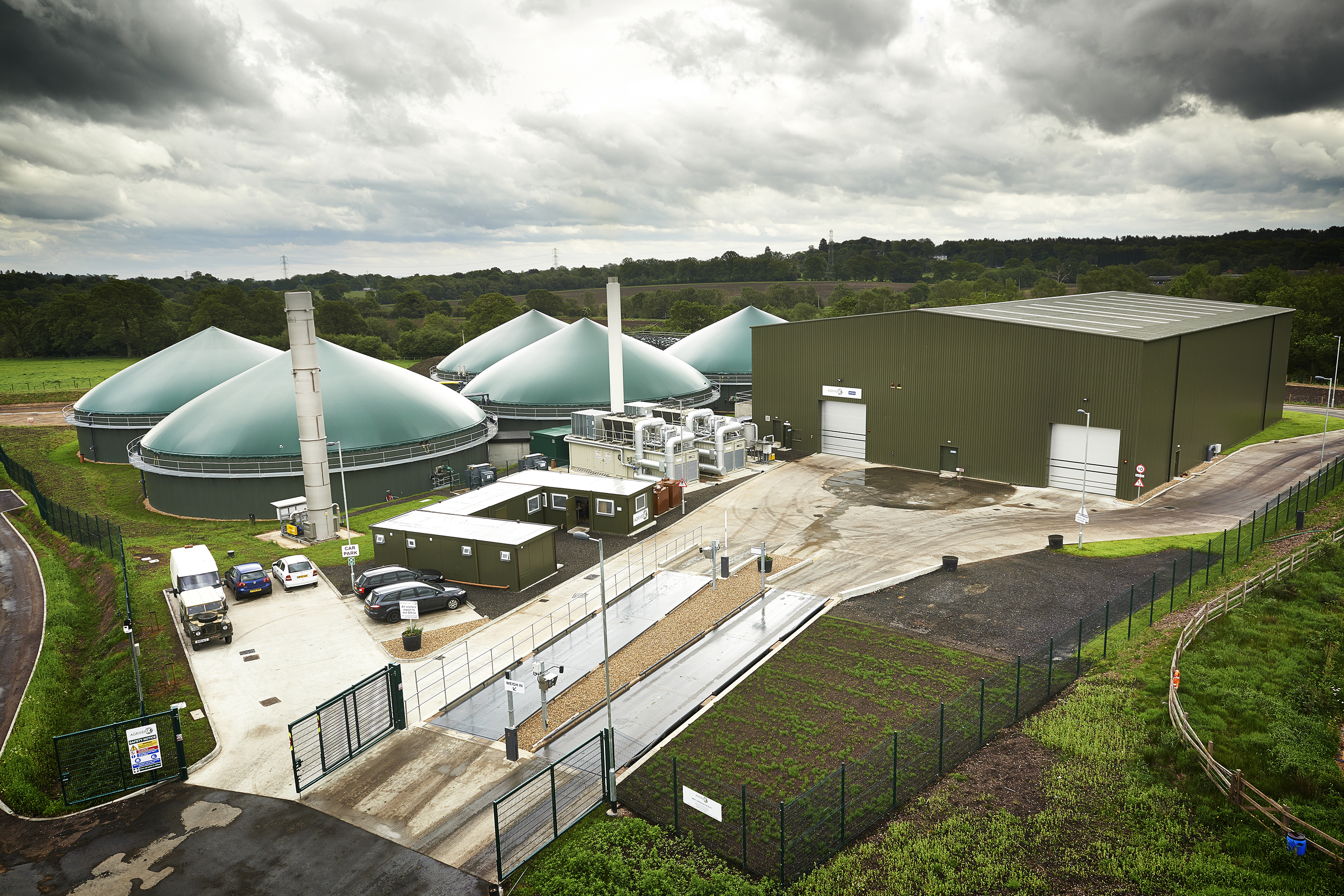 Commercial-scale anaerobic digestion facility processing food waste in West London, with green digesters and industrial buildings